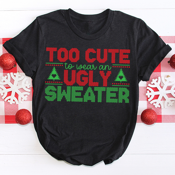 Black t-shirt with bold red and green cross-stitch style lettering that says โToo Cute to Wear an Ugly Sweaterโ with Christmas trees.