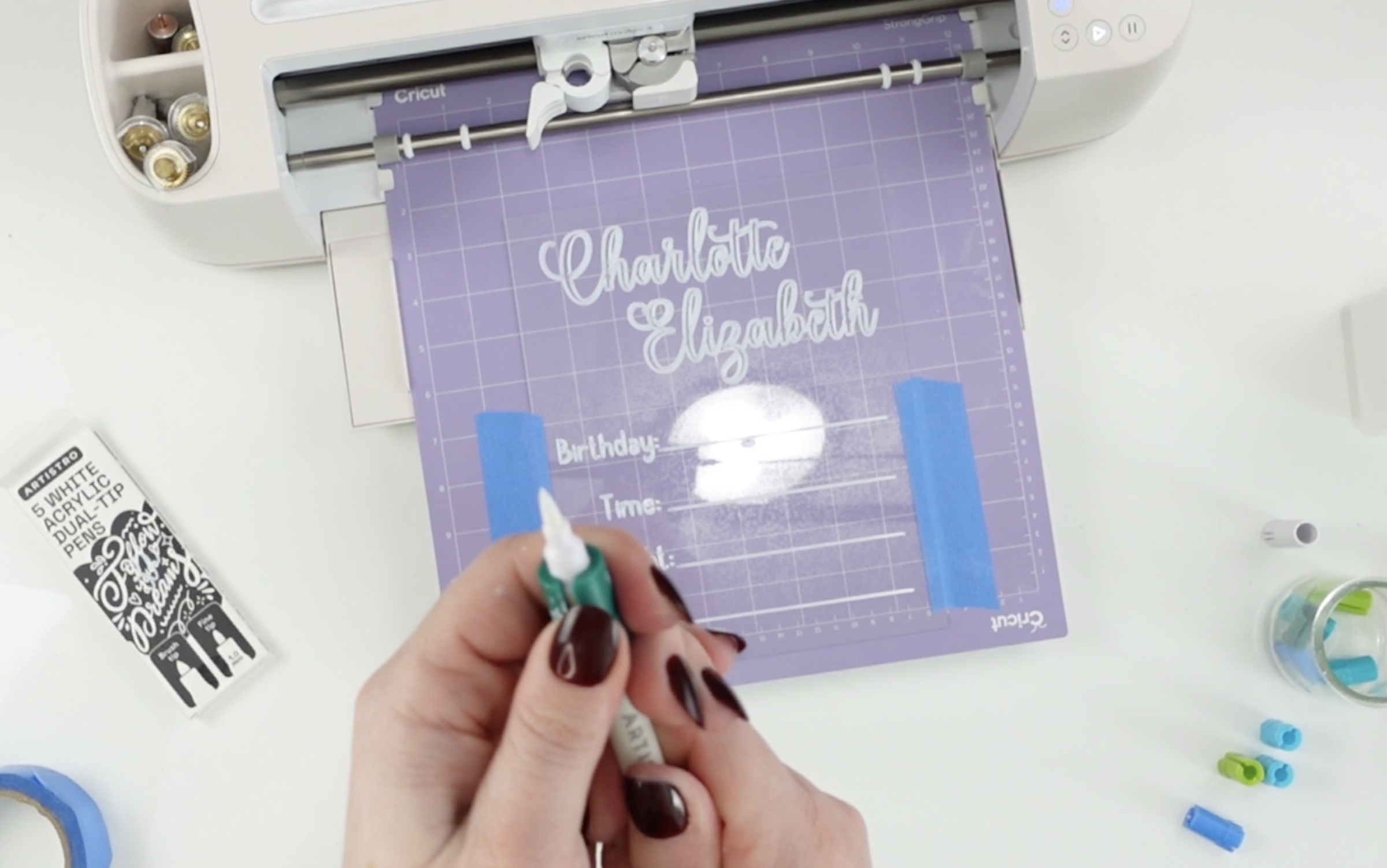 Close-up of a white acrylic marker used for writing on acrylic signs with Cricut.