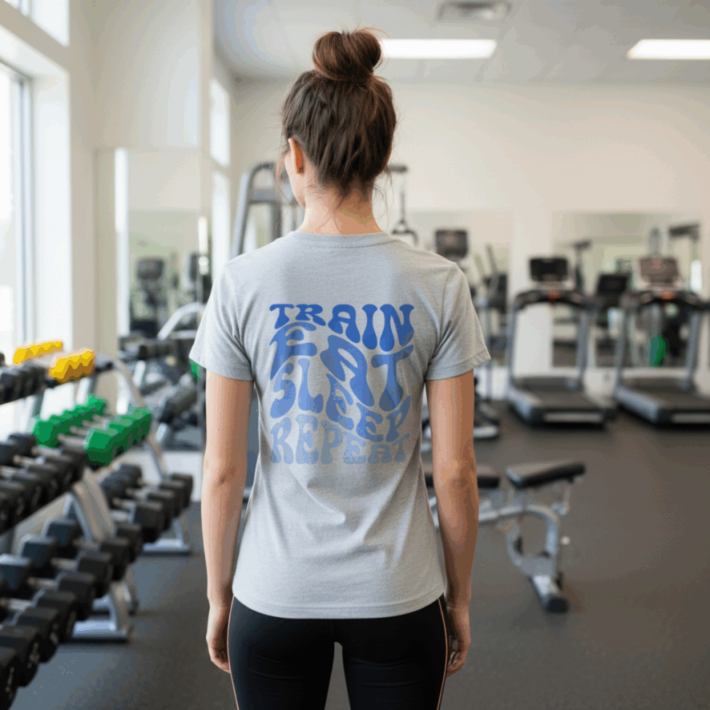 Back view of woman wearing grey t-shirt with blue “Train Eat Sleep Repeat” gym SVG free typography design.
