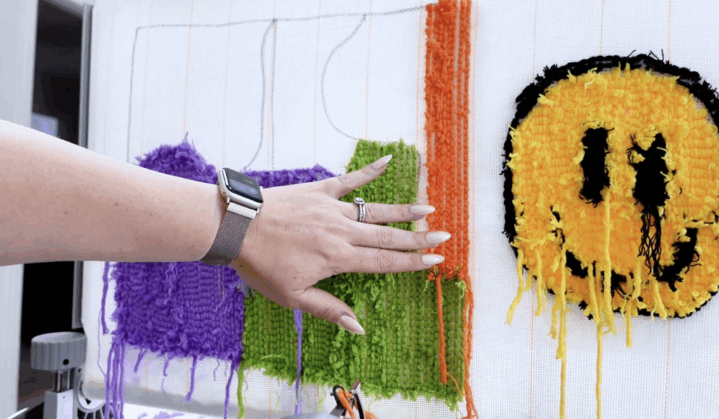 Multiple colorful tufting practice sections including purple, green, orange, and a smiley face design.