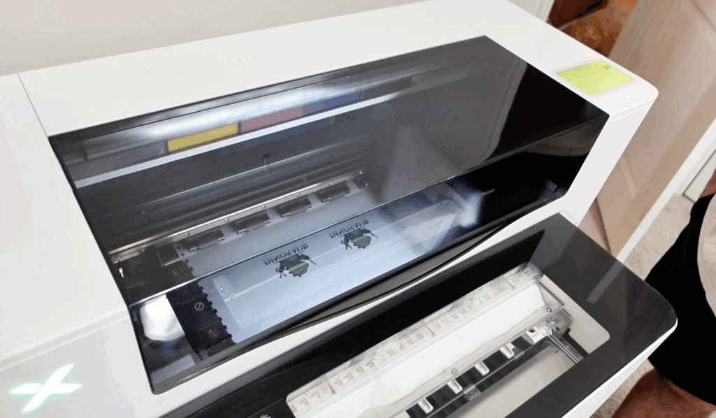 xTool dtf printer actively printing design onto film inside machine.